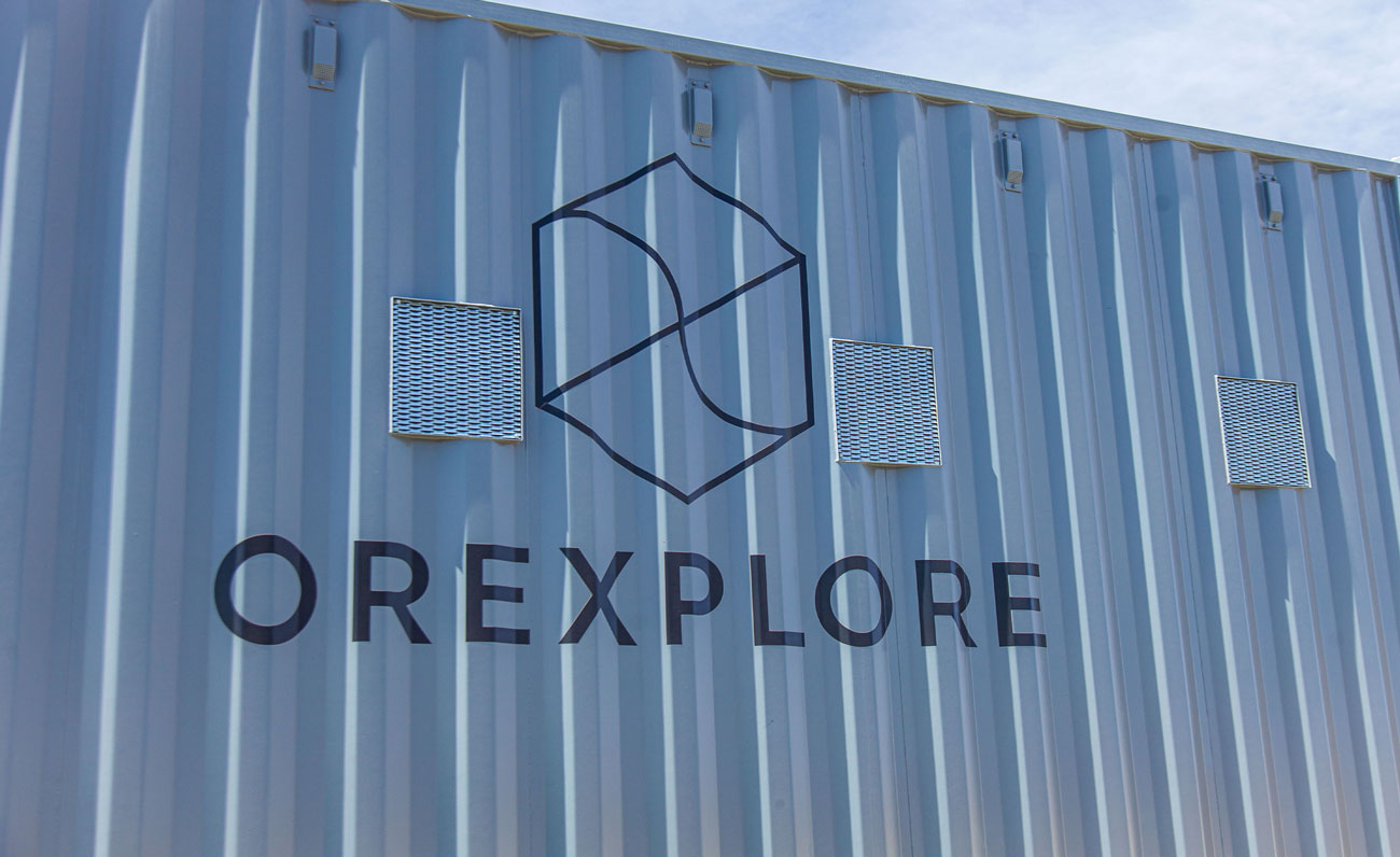 Grey shipping container with Ore Explore logo on the side